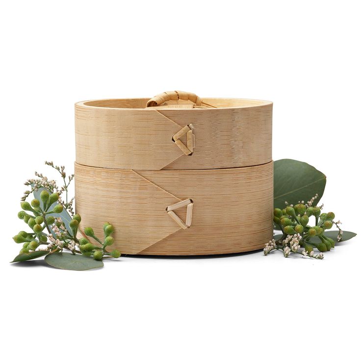 two wooden boxes sitting next to each other on top of a white surface with green leaves