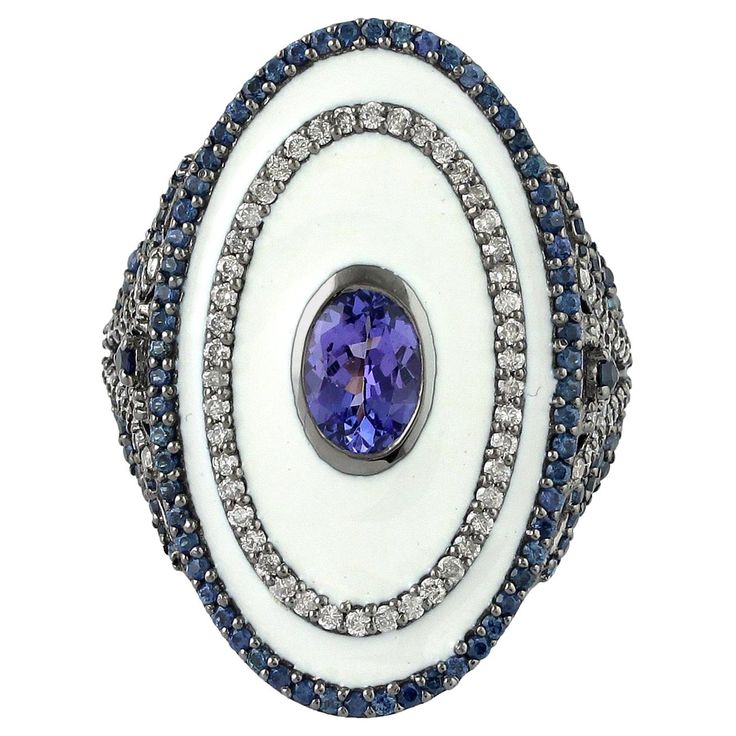 This stunning statement ring has been meticulously crafted from 18-karat gold & sterling silver. It is set with 0.8 carats Tanzanite, 1.04 carats Sapphire & .64 carats of glimmering diamonds. The ring is a size 7 and may be resized to larger or smaller upon request. FOLLOW MEGHNA JEWELS storefront to view the latest collection & exclusive pieces. Meghna Jewels is proudly rated as a Top Seller on 1stDibs with 5 star customer reviews. All items manufactured by us are handmade and can be customized Antique Cushion Cut Diamond, Oval Shape Ring, Diamond Dress Ring, Tanzanite Diamond Ring, Round Sapphire, Platinum Diamond Rings, Contemporary Ring, Diamond Cocktail Rings, Sapphire Diamond Ring