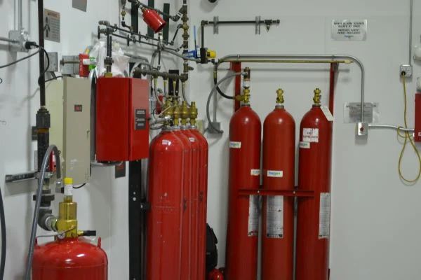 red fire extinguishers are lined up in a room with white walls