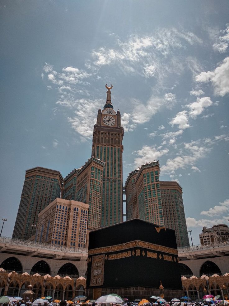 the kabab is surrounded by tall buildings and umbrellas under a cloudy blue sky