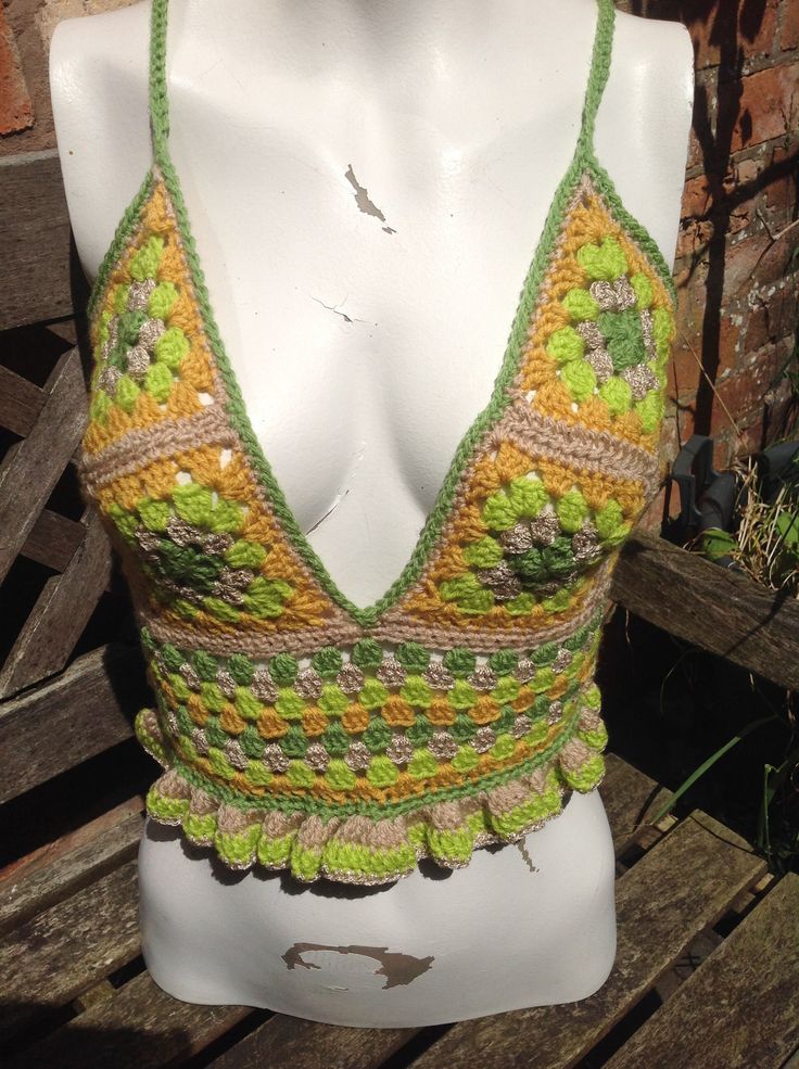 a white mannequin wearing a green and yellow crochet top