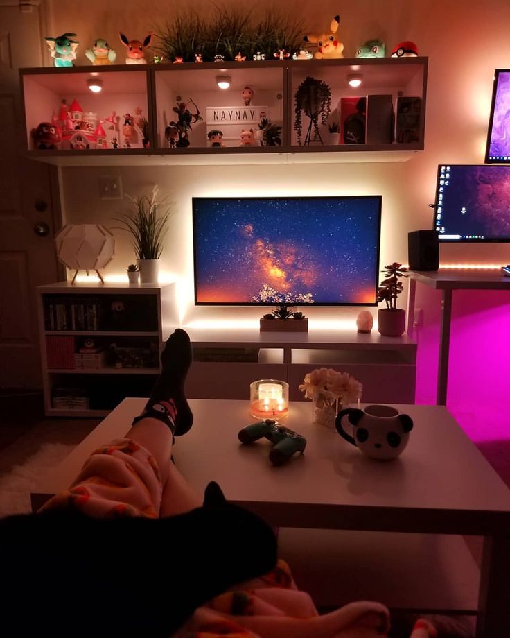 a person sitting on a couch in front of a flat screen tv with the lights on