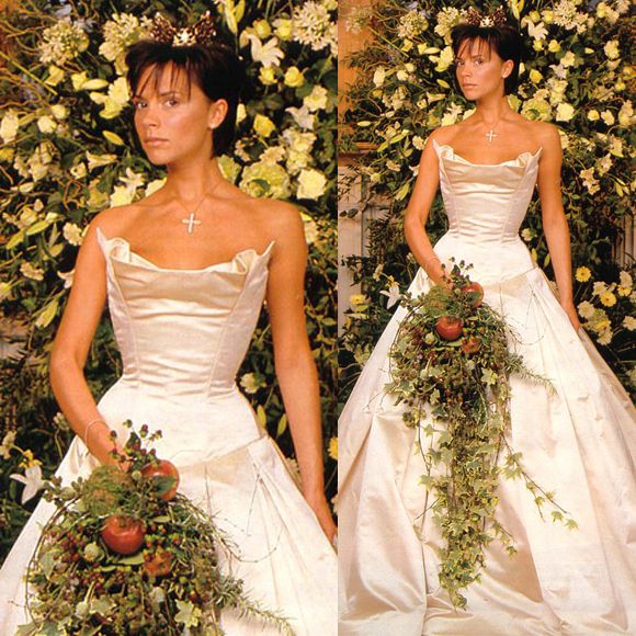 a woman in a wedding dress with flowers on her head and holding a flower bouquet