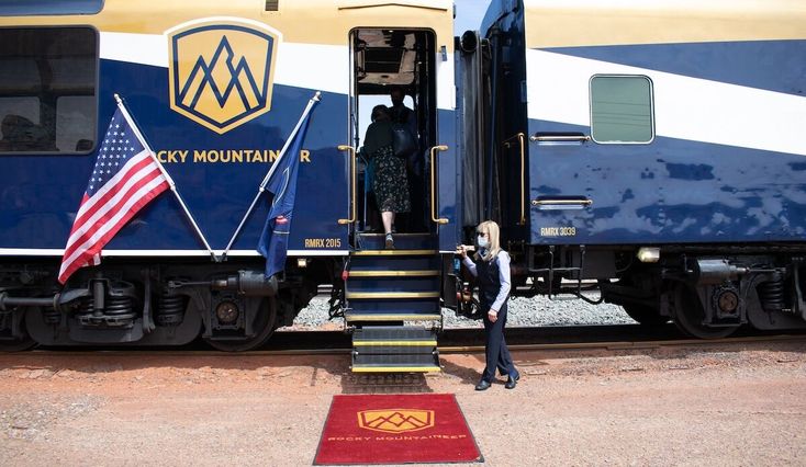 a train with stairs leading up to it and a person standing on the platform next to it