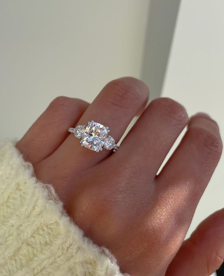 a woman's hand with a diamond ring on it