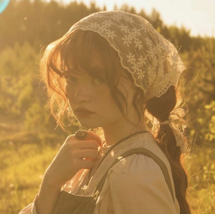 a woman with a white lace hat on her head is holding something in her hand