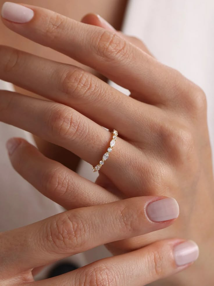 a woman's hand with a diamond ring on her left hand and the other hand holding