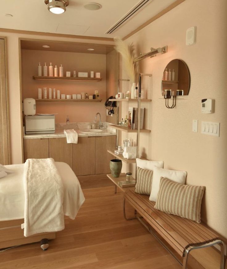 a room with a bed, couch and shelves on the wall above it that are filled with personal care items