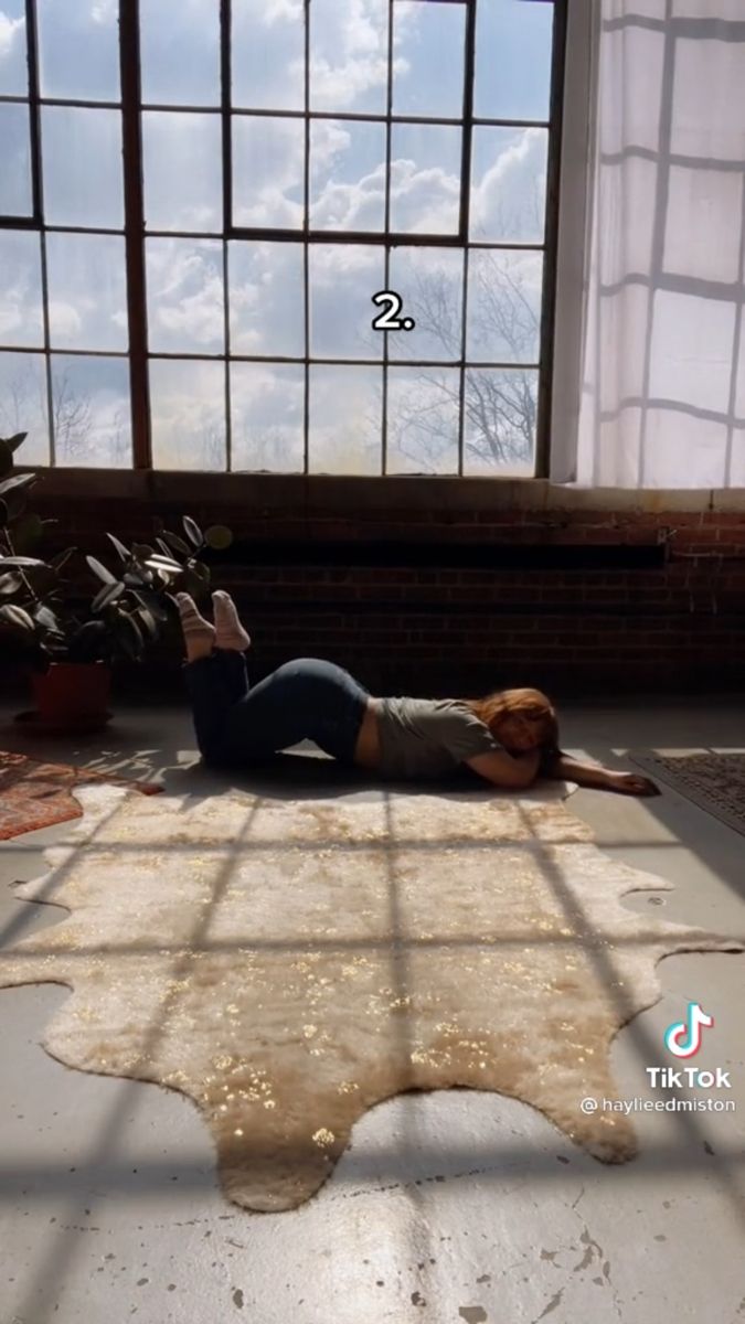 a woman laying on the floor in front of a window