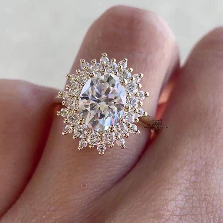 a woman's hand with a diamond ring on top of her finger and an engagement band