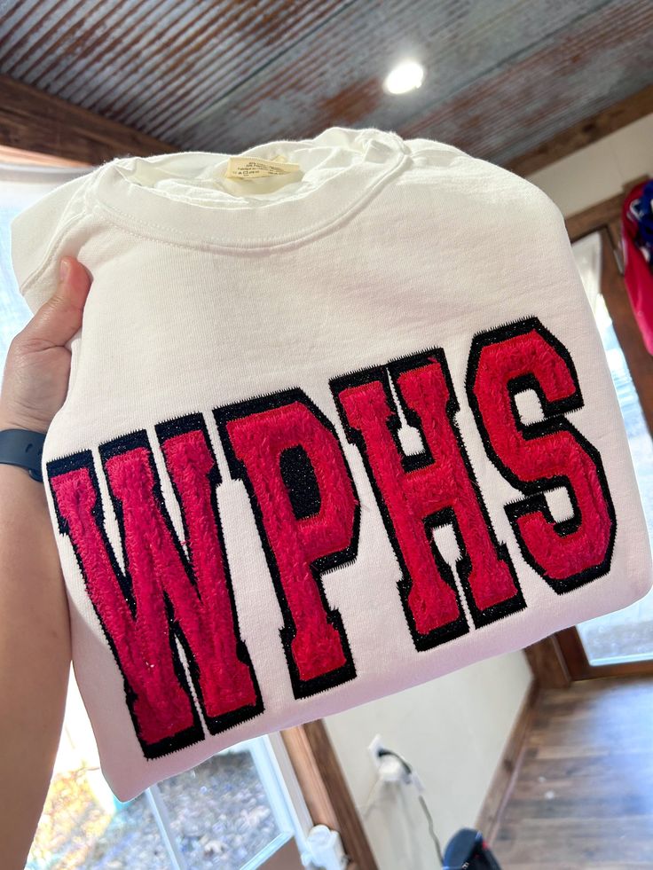 someone holding up a t - shirt with the word wpps on it