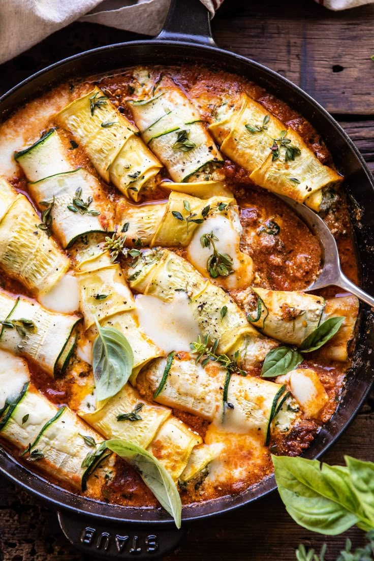 a pan filled with ravioli and cheese on top of a wooden table