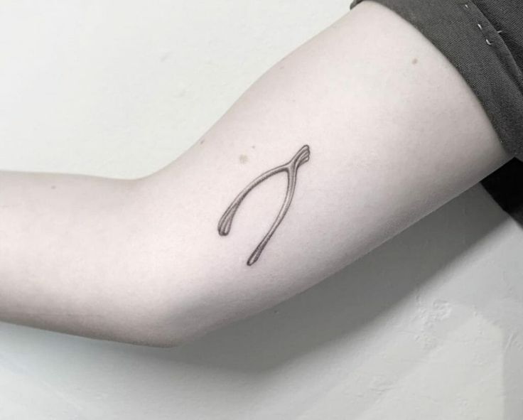 a person's arm with a small tattoo on the left side of their arm