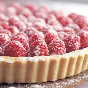 a tart crust topped with raspberries and powdered sugar