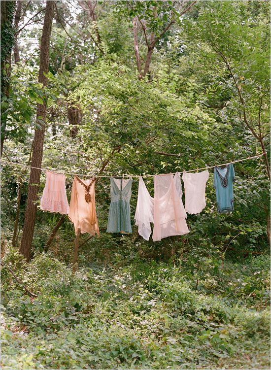 clothes hanging out to dry in the woods with trees and bushes behind them on a line