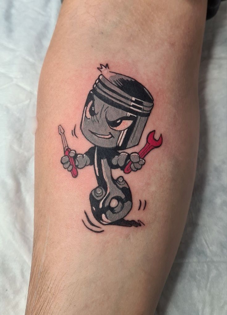 a cartoon character holding a wrench and spanner tattoo on the right calf leg