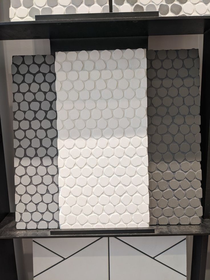 some white and black tiles are stacked on top of each other in the same room