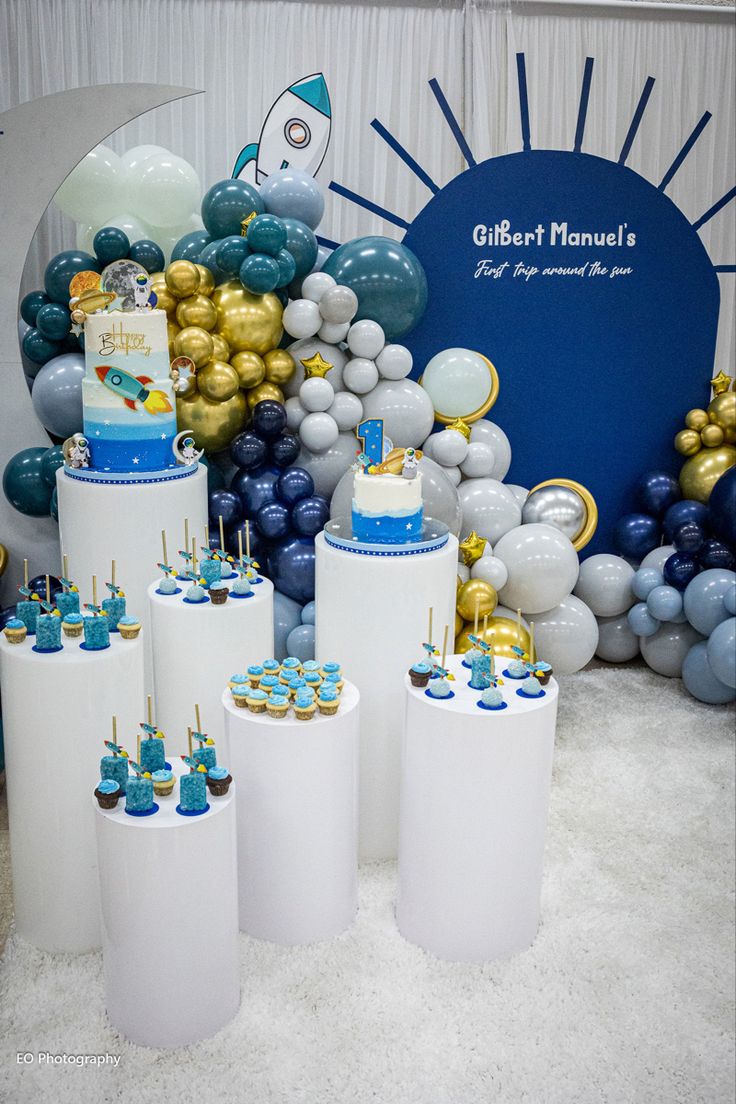 blue and white desserts are displayed in front of balloons