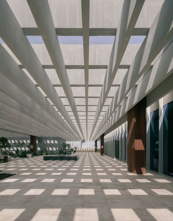 an empty building with lots of windows and long lines on the ceiling that lead up to it