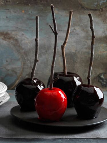 three black and red apples on a plate