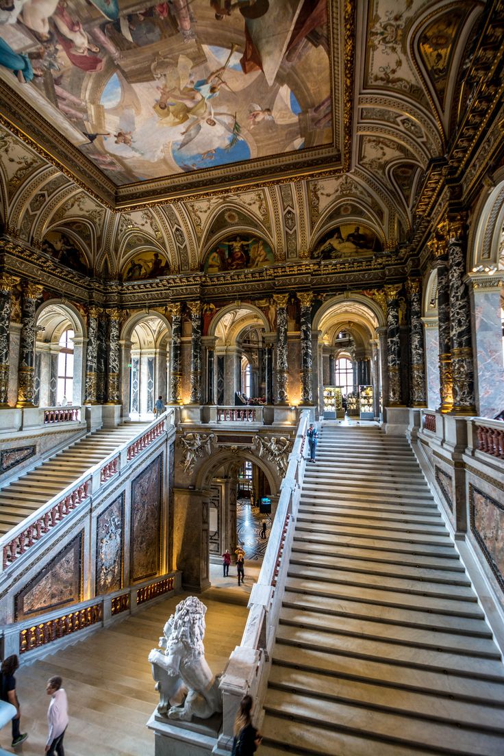 an ornate building with stairs and paintings on the ceiling