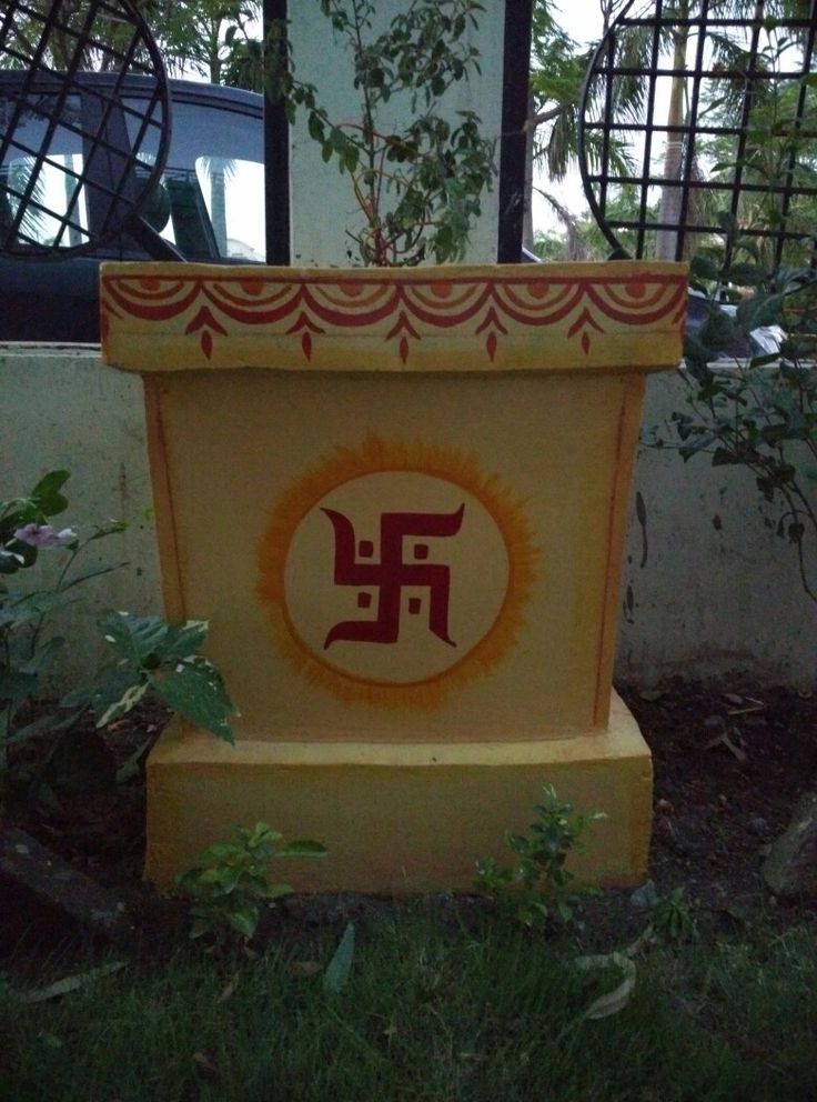 a yellow and red planter sitting on top of a lush green field