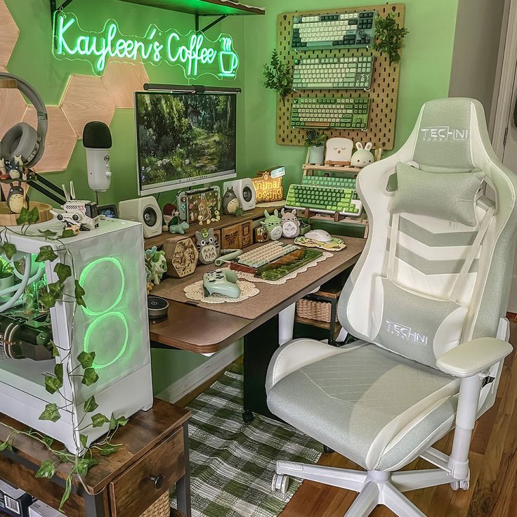 a desk with two chairs and a computer monitor on it in front of a green wall