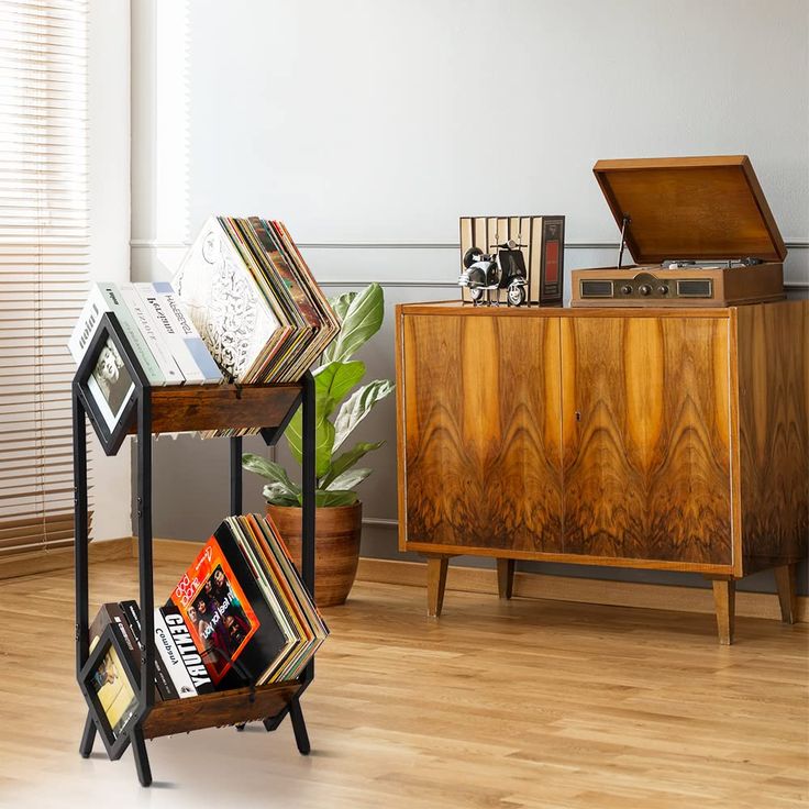 an old record player sits on a stand in front of a wooden cabinet with books