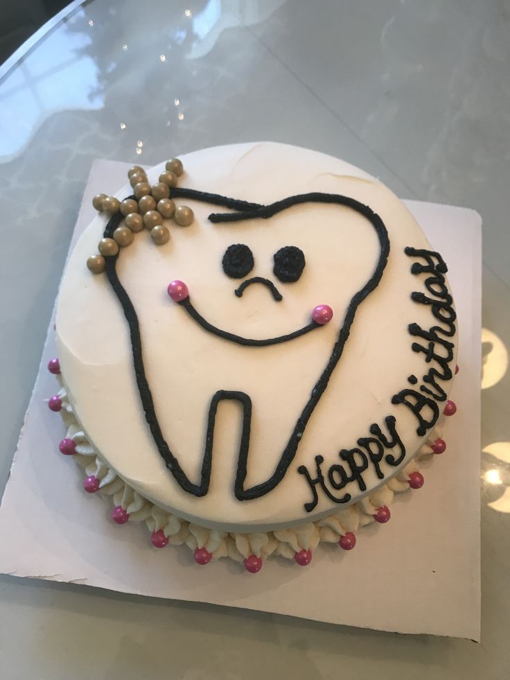 a decorated birthday cake with a tooth on it