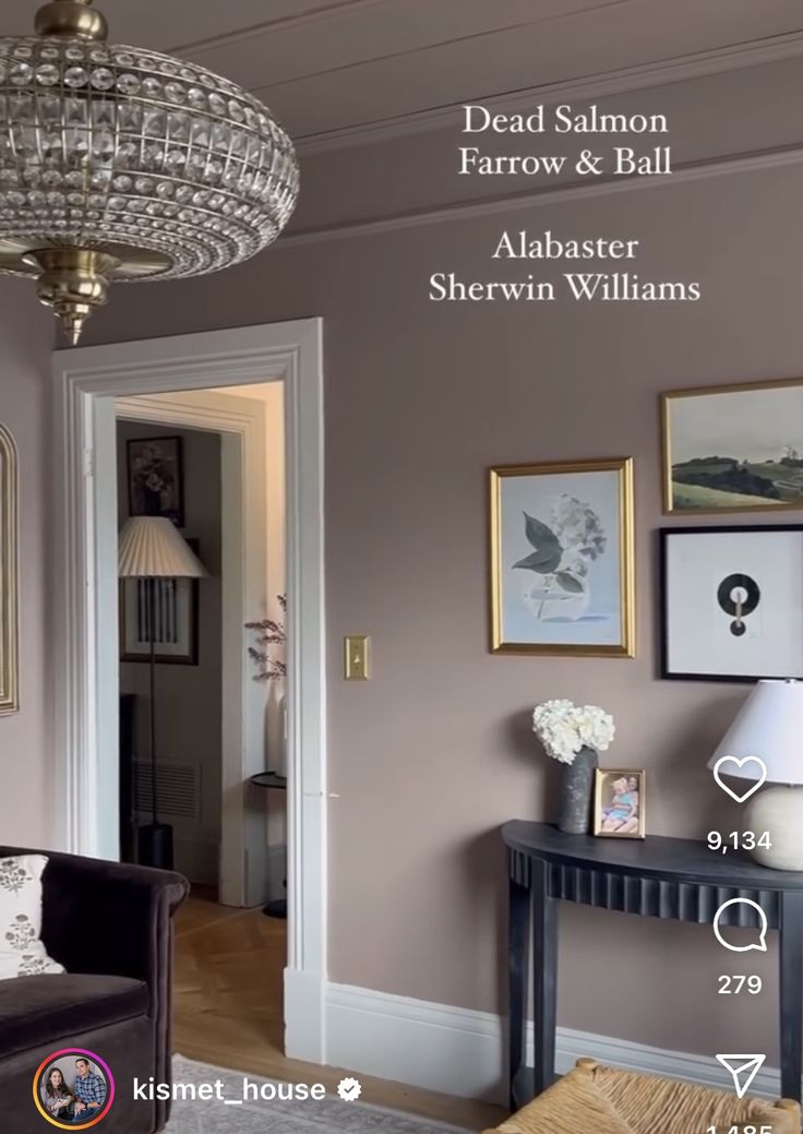 a living room with pictures on the wall and chandelier hanging from the ceiling