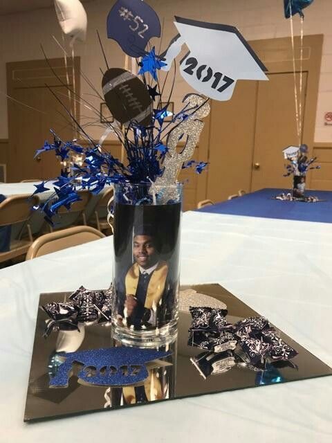 a table with a vase filled with blue and silver decorations on it's centerpiece