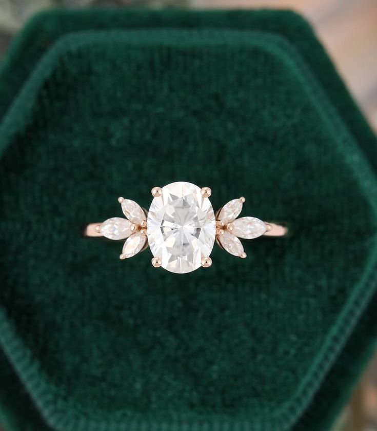 an engagement ring in a green velvet box on top of a carpeted surface with a diamond center stone