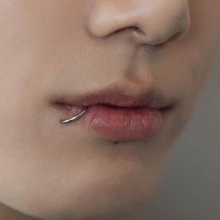 a woman's nose with piercings on it