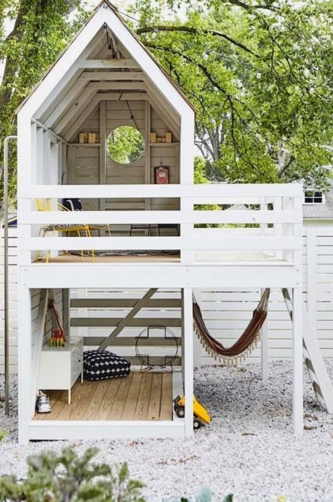 a white house with a hammock on the roof and stairs leading up to it