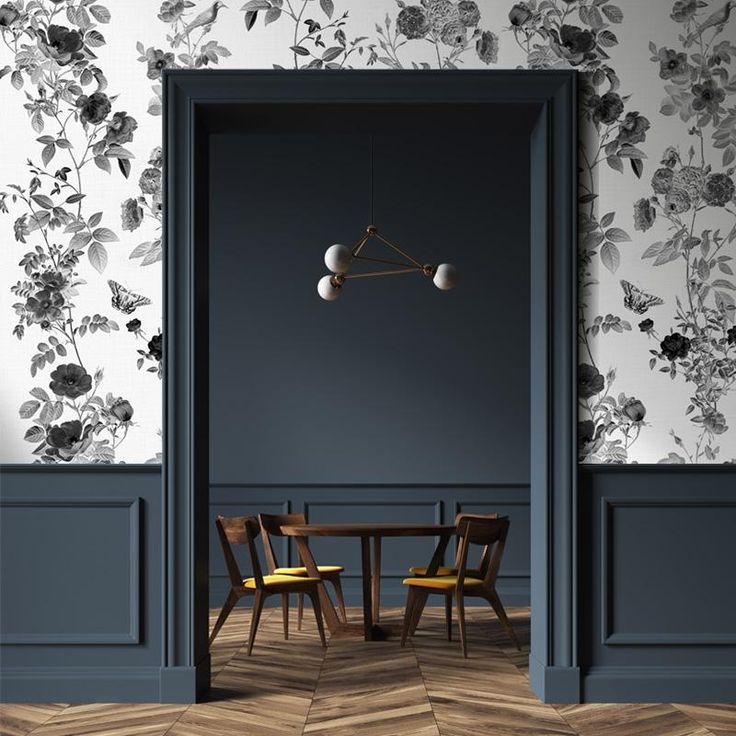 an open door leading to a dining room with floral wallpaper