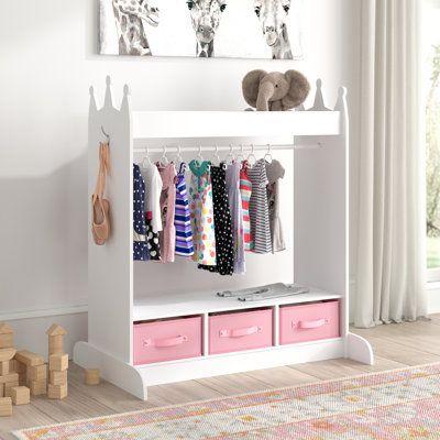 a white shelf with pink drawers and clothes hanging on it