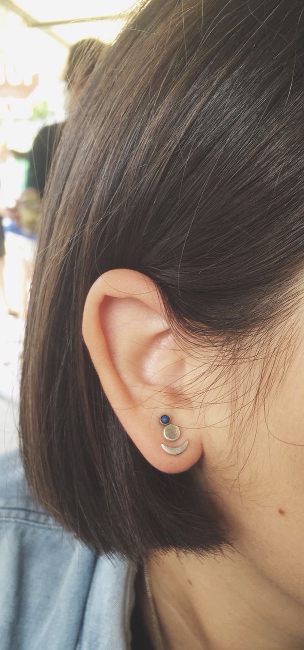 a close up of a person's ear with an earring in the shape of a circle