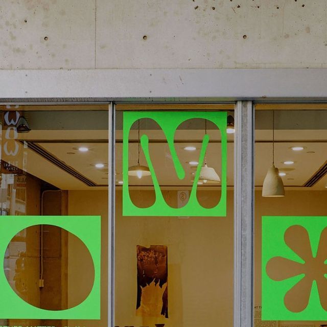 a store front window with green and white designs on it's glass door windows