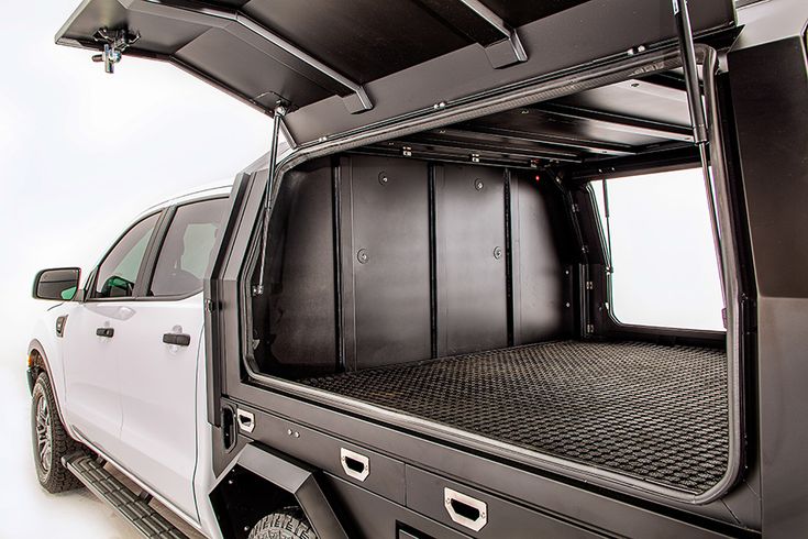 the back end of a white truck with its doors open