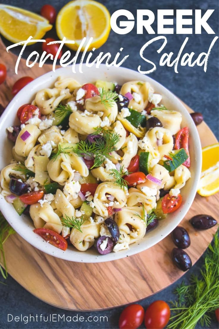 a white bowl filled with tortellini salad on top of a wooden cutting board