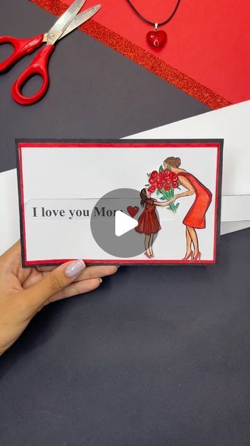 someone is holding up a card that says i love you mom with scissors next to it