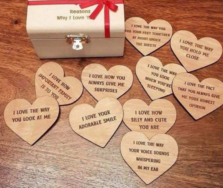 wooden hearts with i love you messages on them sitting next to a box and ribbon