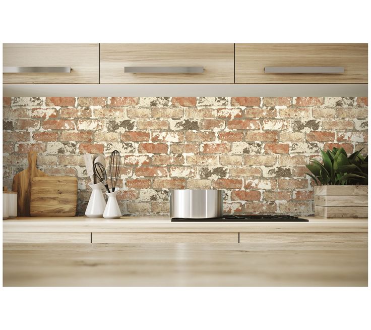 a kitchen counter with pots and utensils in front of an old brick wall