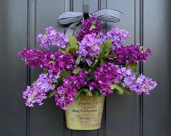 purple flowers in a pot hanging on the front door