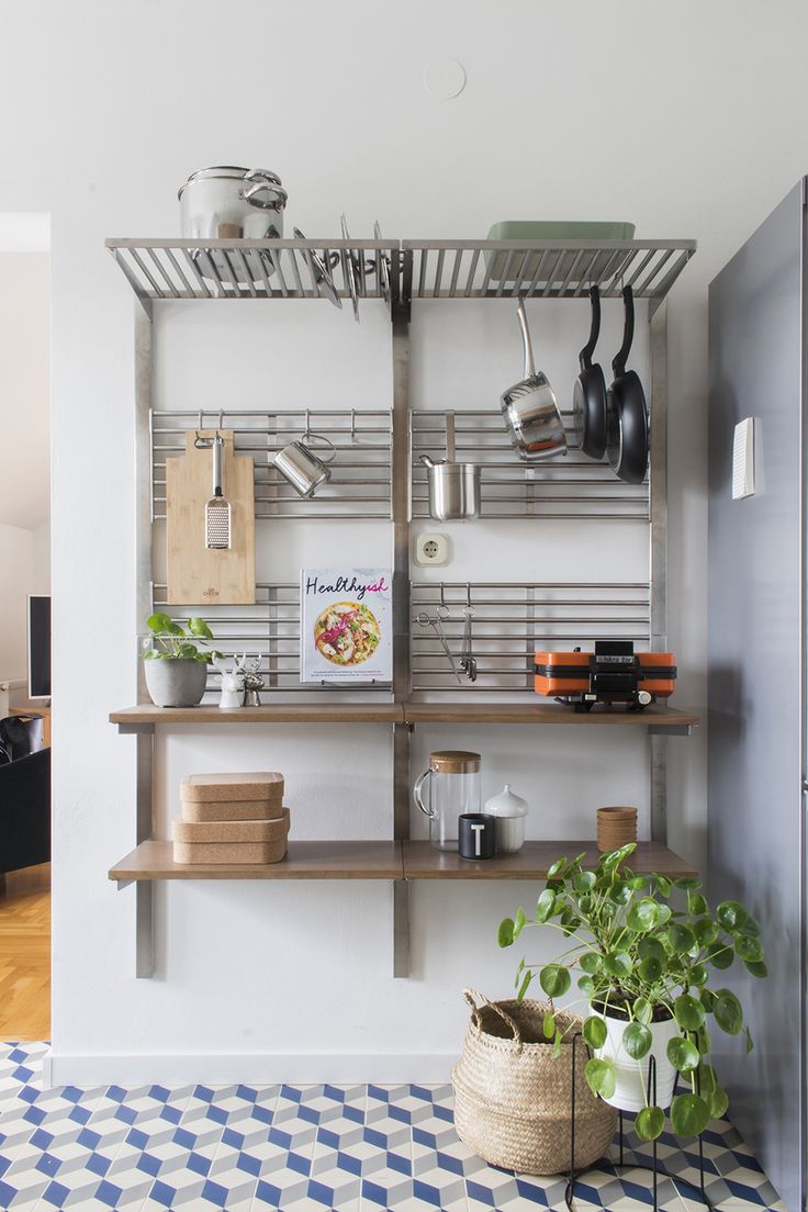 a shelf with pots, pans and other kitchen items on it in a living room