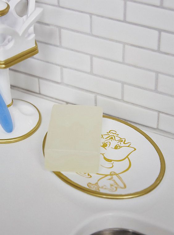 a bathroom sink with a soap dispenser and toothbrush holder