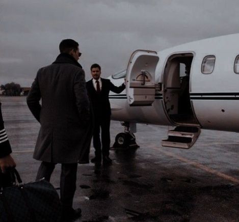 three men in suits are getting off an airplane and shaking hands with one another on the tarmac