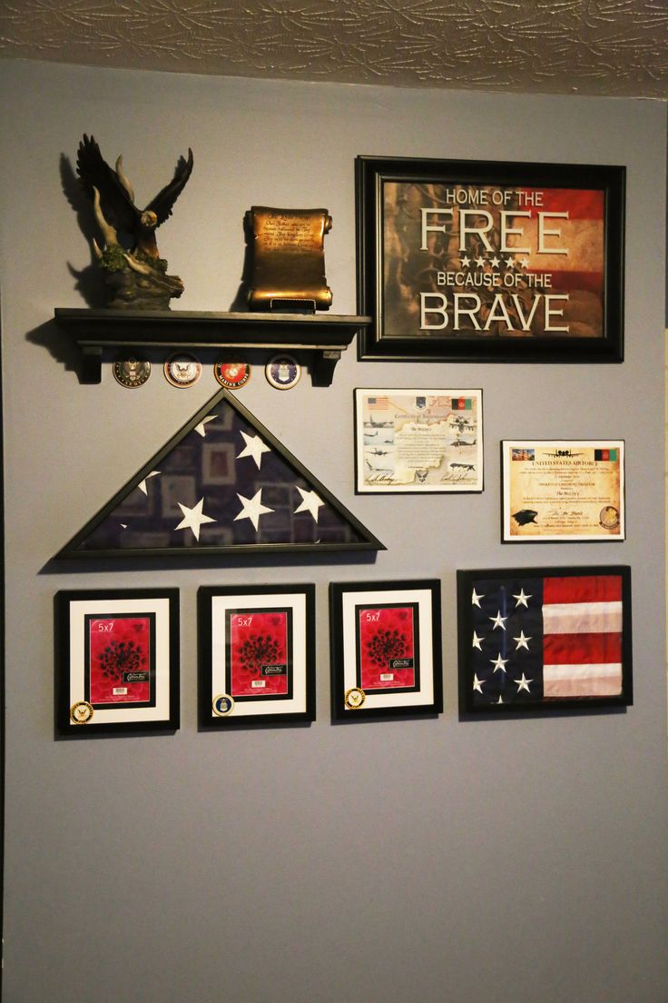 the wall is decorated with american flags, plaques and framed pictures on it's sides