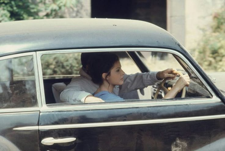 a woman sitting in the driver's seat of a car