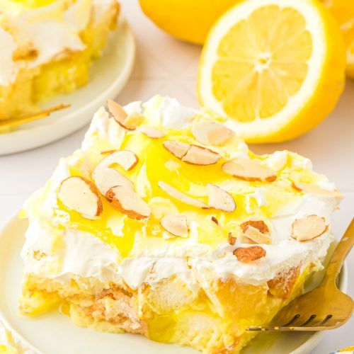 there is a piece of cake with lemons on the table next to other plates